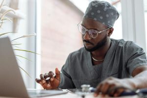 A imagem contém um médico consultando um prontuário eletrônico em seu tablet, um exemplo de tecnologia na Medicina.