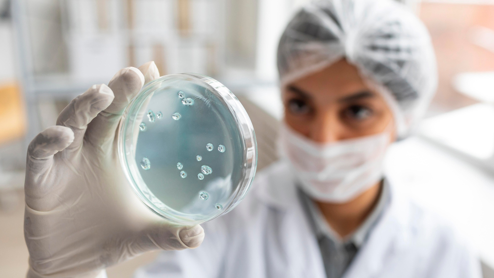 Cientista desfocado segurando uma placa de Petri.