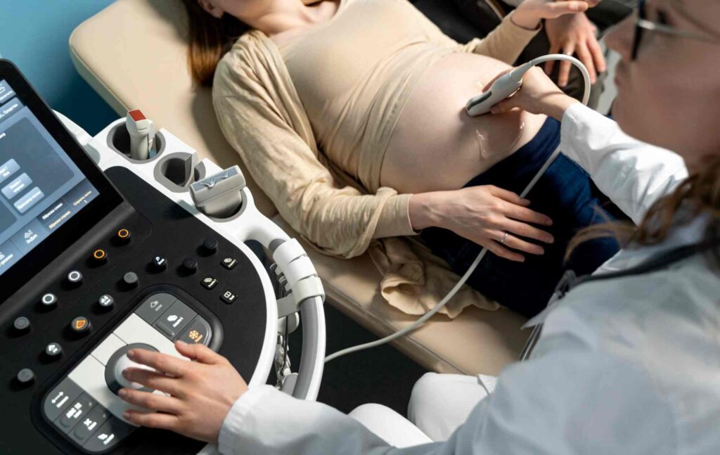 Mulher grávida deitada fazendo ultrassom.